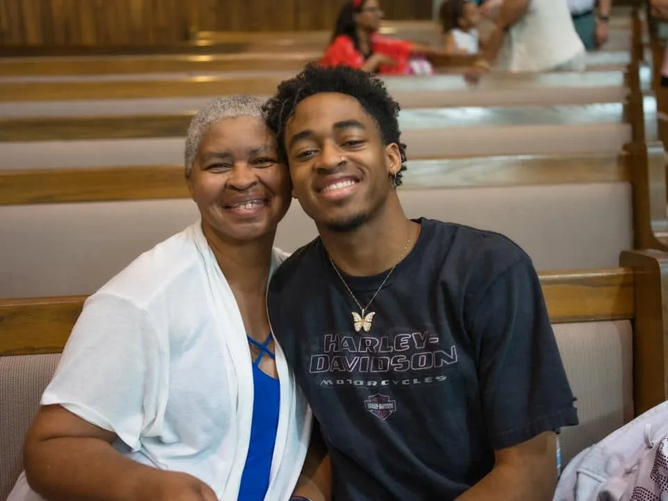 Two members of the congregation together in the pews before worship